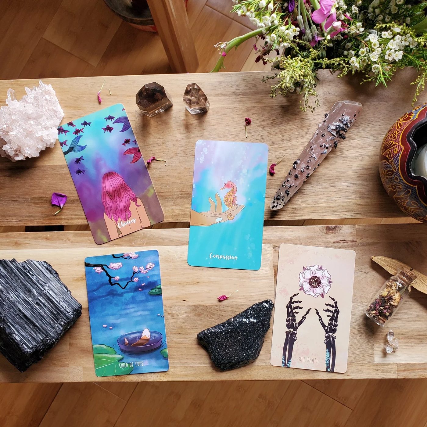 Cartas de tarot, cristales y flores sobre una mesa